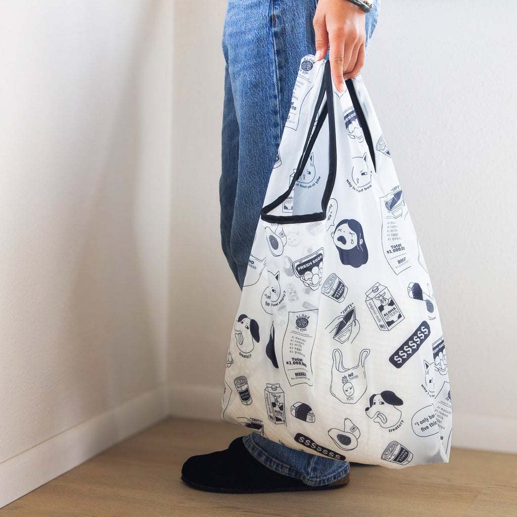 Person holding a patterned reusable bag against a plain background